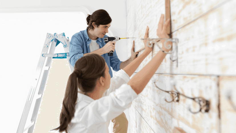 Couple attaching flat wood board on their wall