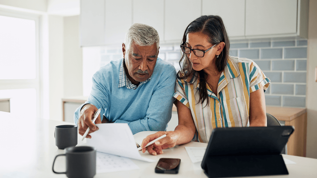 Senior couple reviewing property tax exemption documents at home together