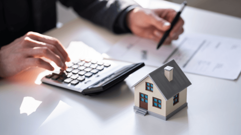 Reviewing tax rate paperwork with a calculator and house model