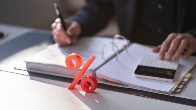 Accountant calculating mill rate figures beside a red percentage sign
