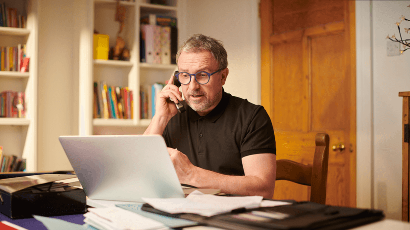 Homeowner reviewing property tax documents and calling a consultant for help