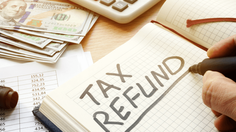 Person noting property tax refund amount alongside exemption documents and money